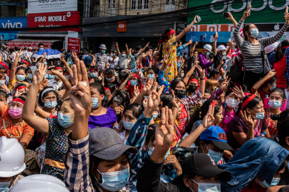 Protestors make three-finger salutes during an anti-coup march on Saturday in Yangon.