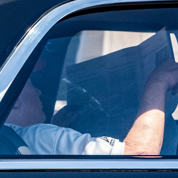 President Donald Trump reads the Wall Street Journal as he returns to his Mar-a-Lago club from Trump National Golf Club on Saturday.