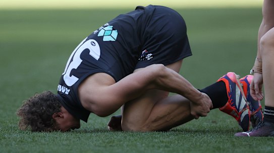 Gone: Charlie Curnow clutches his left ankle in pain on a dirty day for the Blues.