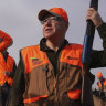 Flanked by his Secret Service detail, Minnesota governor and Democratic Vice Presidential candidate Tim Walz stops during a break to give water to the hunting dogs during the annual Minnesota Governor’s Pheasant Hunting Opener. 