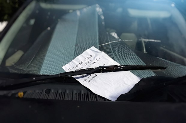 Stock image of a note left on a car's windshield