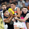 Nick Daicos of the Magpies is tackled by Adam Cerra (left) and Blake Acres of the Blues.