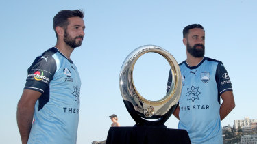 Champions: Sydney FC's Alex Brosque (right) and Michael Zullo (left) with the trophy they hope to keep for another season.