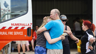 People embrace at the Numeralla Rural Fire Brigade station near where the location of the aircraft's crash.