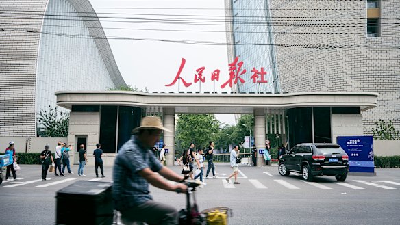 Traffic passes the west security gate of the Beijing offices of the People's Daily and the Global Times, which are both controlled by the ruling Communist Party.