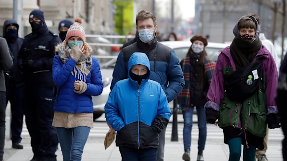 People walk on the streets of Warsaw, Poland, which has been hit by a sudden spike in new COVID-19 cases, as has much of central Europe and the Balkans.