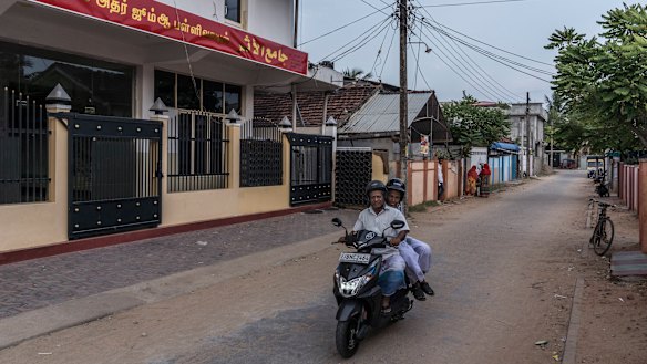 Men drive past a mosque where Zaharan Hashim used to preach in Kattankudy. 
