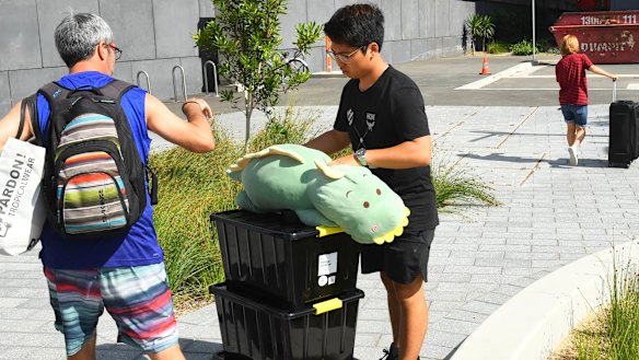 Residents battle 35-degree heat as they carry belongings out of Opal Tower.