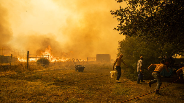 A family works to protect property as a fire approaches in Vacaville, California.