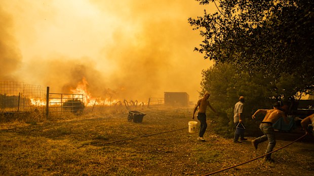 A family works to protect property as a fire approaches in Vacaville, California.