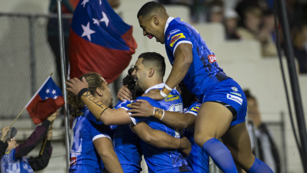 Group hug: Samoa celebrate a try to Jarome Luai.