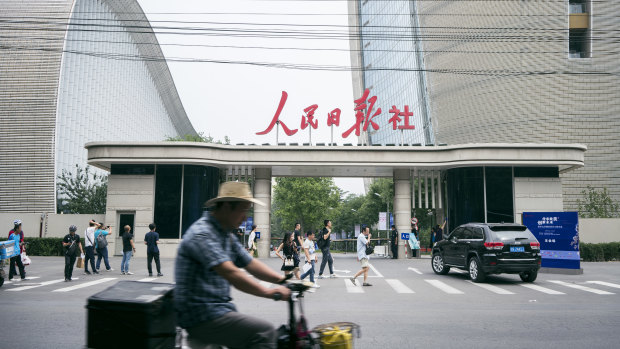Traffic passes the west security gate of the Beijing offices of the People's Daily and the Global Times, which are both controlled by the ruling Communist Party.