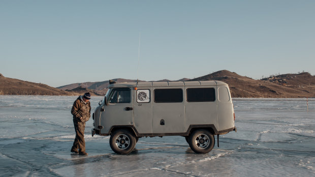 A van used to transport visitors to Olkhon Island, on the frozen surface of Lake Baikal, Russia.