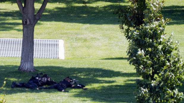 Two police officers with rifles lay near the Library of Congress.