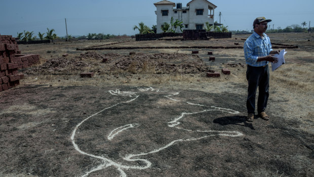 Amateur archaeologist Dhananjay Marathe near a petroglyph made prominent when sand is used to fill the deep grooves of the carving.