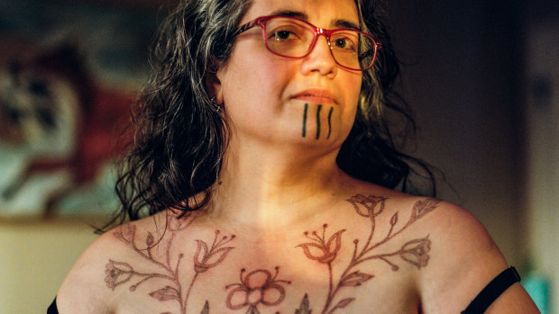 Grete Chythlook shows off a chest piece by Sarah Whalen-Lunn, a traditional tattooist, that was inspired by traditional native beadwork, in Anchorage, Alaska.