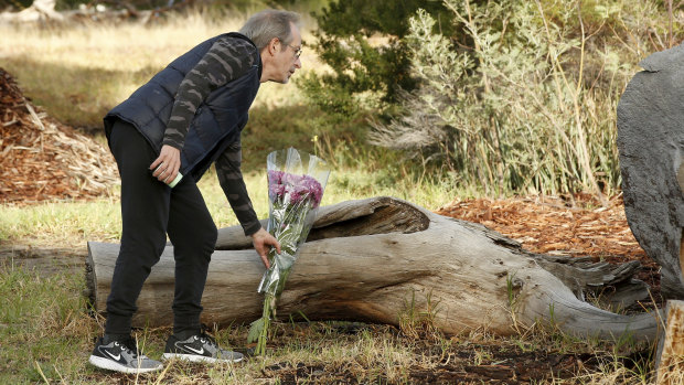 A man lays flowers at the murder scene.