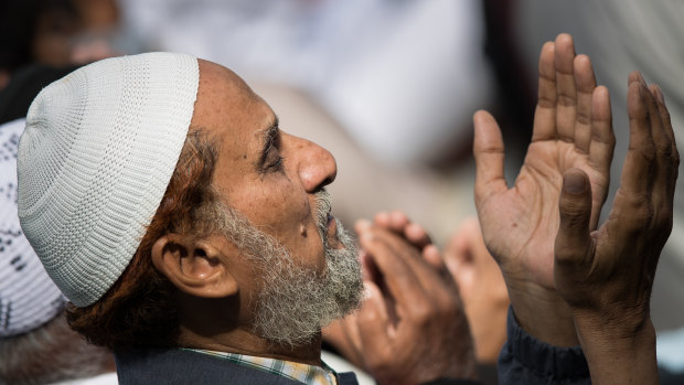 A man  prays in Hagley Park across from the Al Noor Mosque at a national call to prayer on Friday.