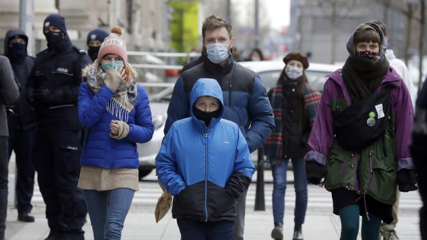 People walk on the streets of Warsaw, Poland, which has been hit by a sudden spike in new COVID-19 cases, as has much of central Europe and the Balkans.