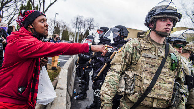 A protester points at a National Guardsman during protests after police fatally shot a black man in Minnesota.