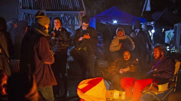 Protesters gather around a fire at the Ihumatao protest site.