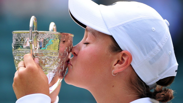 Ash Barty kisses the trophy after taking out the girls singles final at Wimbledon in 2011.