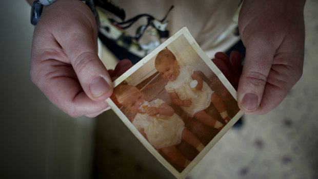 Samantha Long holds a picture of herself and her twin sister Etta. 