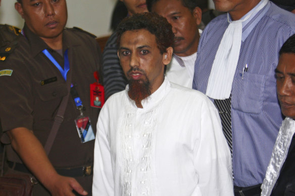 2002 Bali bombalamasının bomba yapımcısı Umar Patek, Mayıs 2012'de Endonezya'nın Jakarta kentindeki Batı Jakarta bölge mahkemesindeki duruşmasının ardından mahkeme salonundan çıkarken savcılar ve sivil giyimli polis memurları tarafından eşlik ediliyor. 