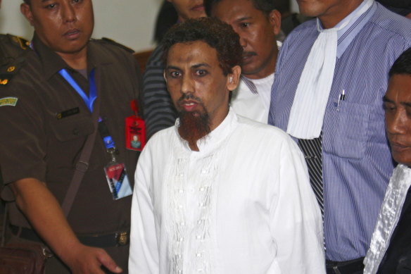 Umar Patek, the bombmaker of a 2002 Bali bombing, is escorted by prosecutors and plain-clothed police officers as he leaves the courtroom after his hearing at West Jakarta district court in Jakarta, Indonesia in May 2012. 