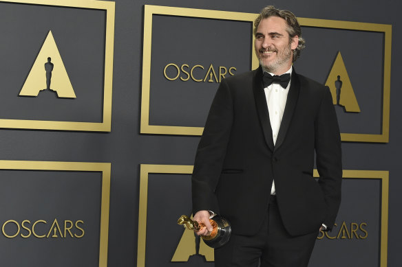 Joaquin Phoenix poses in the press room with his Oscar for best actor in a leading role.