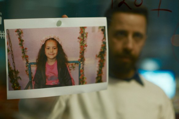 Palestinian actor Motaz Malhees, playing an emergency services worker, holds up a photo of Palestinian child Hind Rajab in The Voice of Hind Rajab.