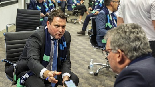 FFA chief executive James Johnson passes his phone to chairman Chris Nikou as they wait for FIFA to announce the hosts of the 2023 Women's World Cup.