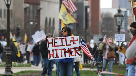Rallygoers protest against Michigan Governor Gretchen Whitmer's stay-at-home order.