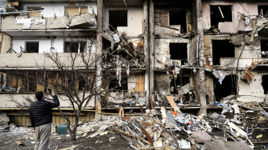 Ukrainians survey debris after a residential building was hit by missiles in the country’s capital of Kyiv.