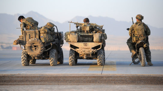 Special Air Service Regiment soldiers, part of the Special Operations Task Group in Tarin Kot, wait for a lift in a US helicopter to their patrol area in Afghanistan.