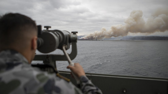 A naval officer inspects the site of a bushfire in 2020.
