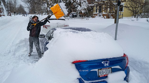 Christian Parker of Buffalo shovels snow off his car in the Elmwood Village neighbourhood on Monday.