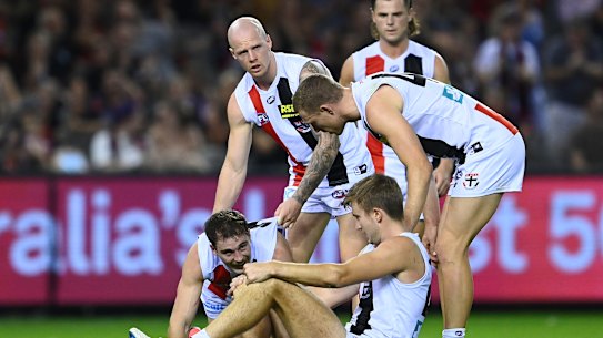 MELBOURNE, AUSTRALIA - APRIL 03: Zak Jones and Callum Wilkie of the Saints help up Daniel McKenzie and Dougal Howard of the Saints after they collided into each other going for a mark during the round 3 AFL match between the Essendon Bombers and the St Kilda Saints at Marvel Stadium on April 03, 2021 in Melbourne, Australia. (Photo by Quinn Rooney/Getty Images)