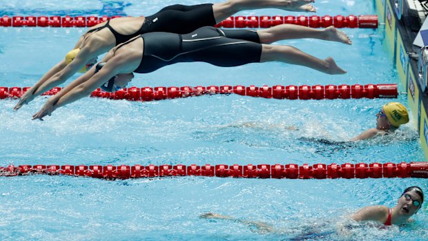Australia’s Emma McKeon and United States Katie McLaughlin dive in together for the final leg of the women’s 4x200m relay final at the World Swimming Championships in Gwangju, South Korea, Thursday, July 25, 2019. (AP Photo/Lee Jin-man )