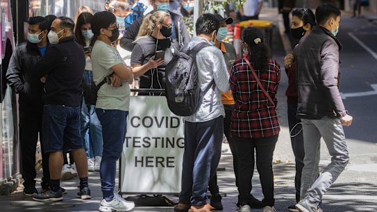 Long lines of people are seen waiting to get a COVID-19 test at the Bourke Street testing clinic on Russell Street, Melbourne.