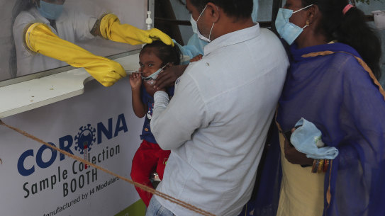 A health worker takes a nasal swab sample from a child at a COVID-19 testing centre in Hyderabad, India.