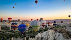 Hot air balloons hover over Cappadocia, Turkiye.