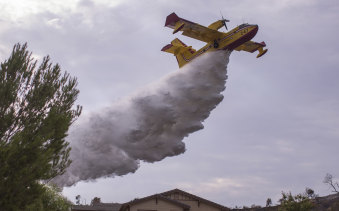A Super Scooper CL-415 firefighting aircraft from Canada makes a drop to protect a house during the La Tuna Fire on September 3, 2017 near Burbank, California. 