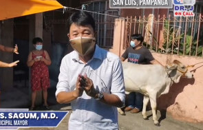 Jayson Sagum, the mayor of San Luis in the Philippines, presents a cow to a raffle winner.