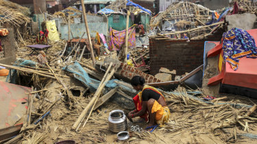 A woman prepares food in the Puri district of Odisha amid the destruction left by Cyclone Puri.  