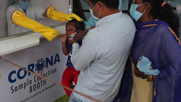 A health worker takes a nasal swab sample from a child at a COVID-19 testing centre in Hyderabad, India.