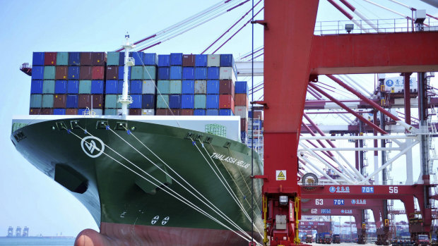A ship hauls containers at a container port in Qingdao in eastern China's Shandong province.