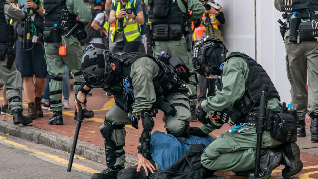 A pro-democracy supporter is detained by riot police during an anti-government rally in Hong Kong, China. 