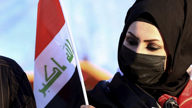 Democracy on the march - again. A woman holds a flag as anti-government protesters gather in Iraq. 