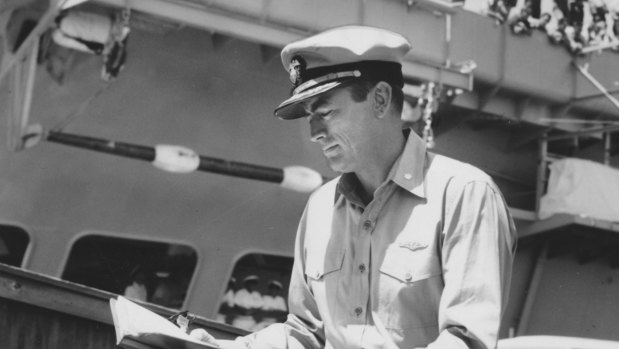 Sailors line the starboard side of H.M.A.S. Melbourne to watch Gregory Peck at work. The aircraft carrier is docked at Gellibrand Pier, Williamstown, to act as a ‘prop’ in the film.